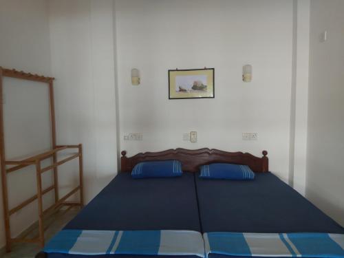 um quarto com uma cama azul com almofadas azuis em Golden Beach Guest House and Restaurant em Hikkaduwa