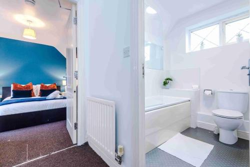 a bathroom with a bed and a toilet and a sink at Inviting 3-Bedroom House in Warrington with Parking and Free Wifi by Amazing Spaces Relocations Ltd. in Warrington