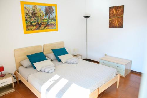 a bedroom with a bed with blue and white pillows at Casa Vittoria in LʼAquila