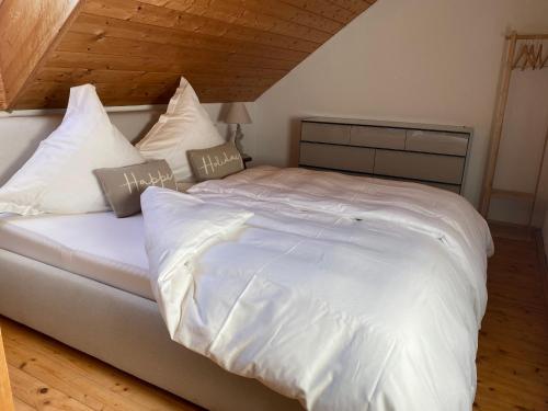 a large bed with white sheets and pillows at Annahof in Argenbühl