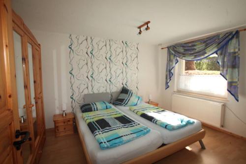 een slaapkamer met een bed met 2 kussens en een raam bij Steinrutsche in Knüllwald
