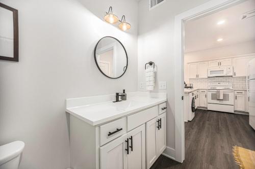 a white bathroom with a sink and a mirror at The Urban Oasis -brand New Corporate Apt Downtown in Grand Rapids