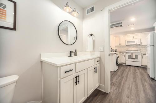 a white bathroom with a sink and a mirror at Upscale Abode - Brand New Corporate Apt Downtown in Grand Rapids