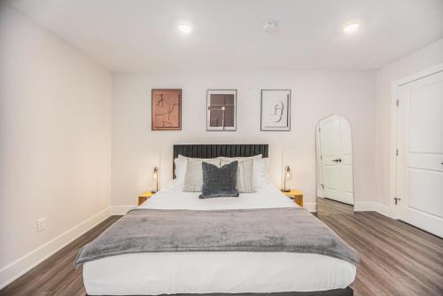 um quarto com uma cama grande e paredes brancas em Cityscape Suite -brand New Corporate Apt Downtown em Grand Rapids