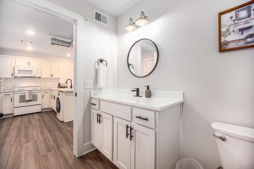 uma casa de banho branca com um lavatório e um espelho em Cityscape Suite -brand New Corporate Apt Downtown em Grand Rapids