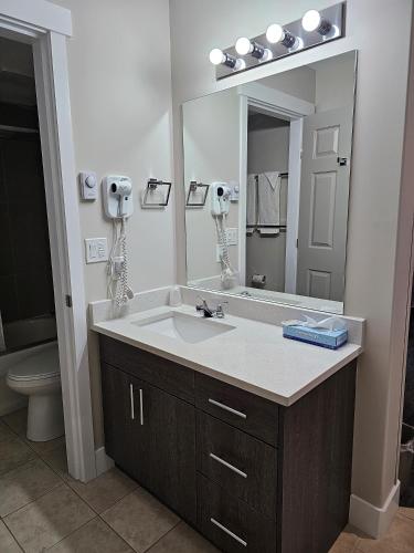 baño con lavabo y espejo grande en Western Budget Motel #1 Leduc/Nisku en Leduc