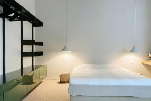Schlafzimmer mit einem weißen Bett und einem Glasschrank in der Unterkunft Charming Heritage 2 BR In Mar Mikhael in Beirut