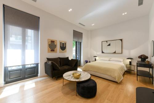 a bedroom with a bed and a couch and a table at Boutique Archaeological Museum Suites in Athens