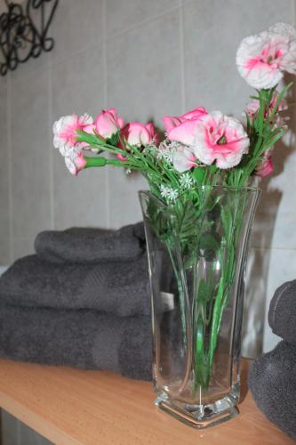 een vaas gevuld met roze bloemen zittend op een tafel bij MarPy Home Verona Fiera in Verona