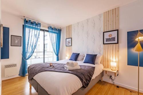 a bedroom with a large bed with blue curtains at Artémis-10 min. from Versailles Gardens, parking in Le Chesnay