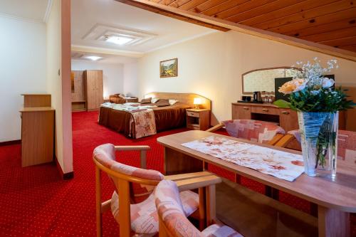 a hotel room with a table and a bed at Piastun SPA&Wellness Krynica-Zdrój in Krynica Zdrój