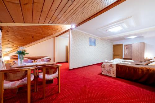 a hotel room with a bed and a table at Piastun SPA&Wellness Krynica-Zdrój in Krynica Zdrój