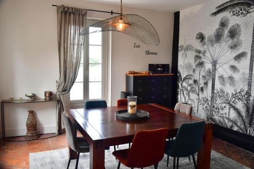 une salle à manger avec une table et des chaises en bois dans l'établissement Les sternes de st Mathurin sur Loire , terrasse sur la Loire, à Saint-Mathurin