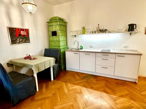 a kitchen with a table and a green fireplace at Baker House in Bolzano