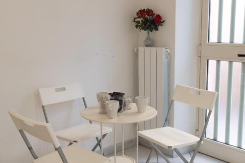 een kleine tafel en stoelen in een kamer met een raam bij Loft moderno amore mio in Formello