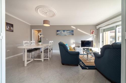 a living room with a table and chairs and a dining room at VARANDAS DO MAR in Furadouro