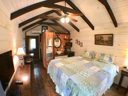 1 dormitorio con 1 cama y ventilador de techo en Tiny Home Cottage Near the Smokies #5 Fleur, en Sevierville