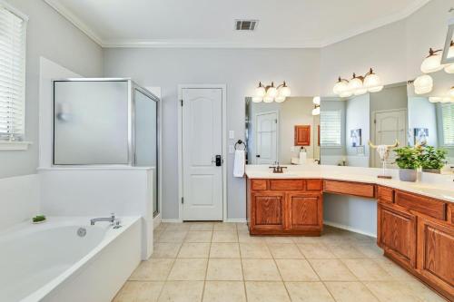 uma casa de banho com uma banheira, um lavatório e um chuveiro em Oak Hollow em Liberty Hill