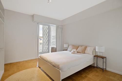 a white bedroom with a white bed and a window at De Meir & Opera Urban Elegance Apt in Antwerp