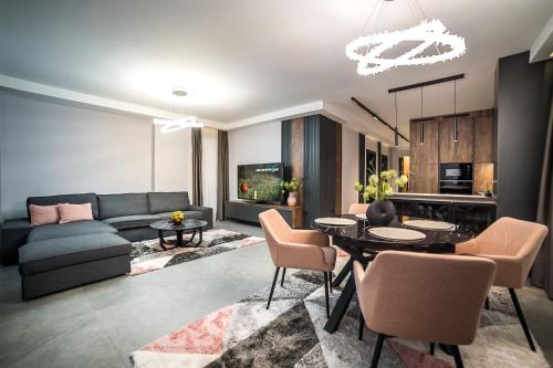 uma sala de estar com um sofá, uma mesa e cadeiras em ARHEYA 4 apart / АРХЕЯ 4 апартамент за гости em Karlovo