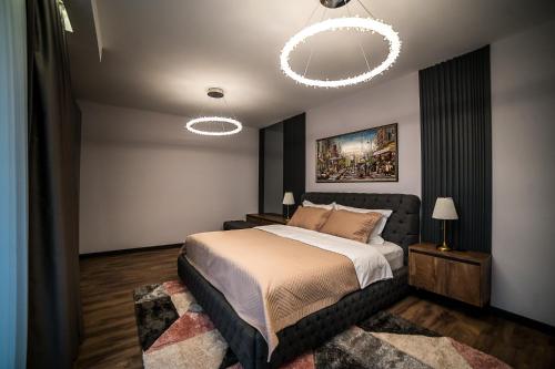um quarto com uma cama grande e um lustre em ARHEYA 4 apart / АРХЕЯ 4 апартамент за гости em Karlovo