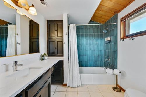 ein Badezimmer mit zwei Waschbecken, einer Badewanne und einer Dusche in der Unterkunft Road Runner Lodge in Austin