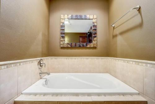 a large white tub in a bathroom with a mirror at WFC IV Adults or Families Lakefront View in Wisconsin Dells