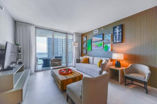 a living room with a couch and a tv at Beachside Condo with a Mesmerizing Ocean View in Hollywood