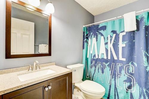 a bathroom with a toilet and a sink and a shower curtain at Destination Dells Vacation Home at Tamarack Resort in Wisconsin Dells