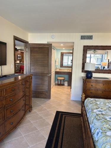a bedroom with a bed with a dresser and a bathroom at Beacon Reef 306 in Islamorada