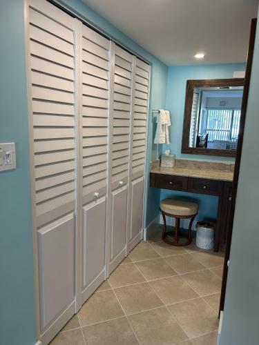 a bathroom with white closet doors and a sink at Beacon Reef 306 in Islamorada