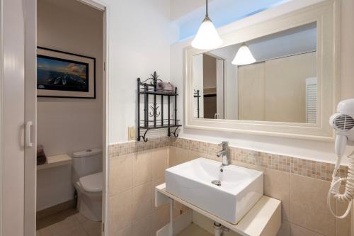 La salle de bains est pourvue d'un lavabo, de toilettes et d'un miroir. dans l'établissement MariaMar Suites, à San José del Cabo