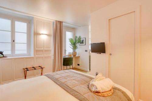 Schlafzimmer mit einem Bett, einem TV und einem Fenster in der Unterkunft Git le cœur in Paris