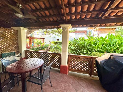 a patio with a table and chairs on a porch at Peaceful Bliss Condo Inside A 6 Pool Complex in Coco