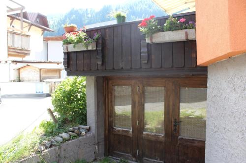 a house with a wooden door with potted plants on it at Aktivurlaub Morandell in Sölden