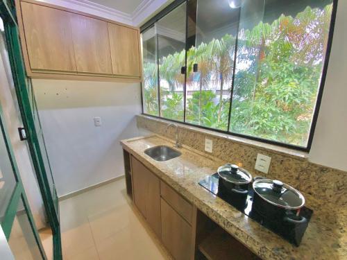 uma pequena cozinha com dois lavatórios e uma janela em Spazio Vital Apartments em Florianópolis