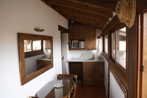a small kitchen with a table and a mirror at Pedraza Suite in Pedraza-Segovia