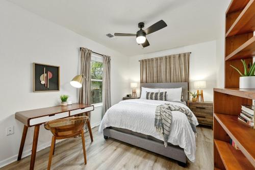un dormitorio con una cama y un escritorio en Oak Grove Bungalow, en Austin