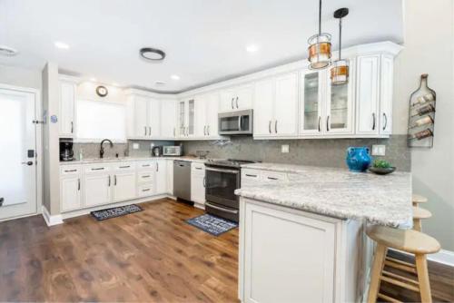 a kitchen with white cabinets and a wooden floor at LAKEFRONT PENTHOUSE FULLY UPGRADED PANORAMIC VIEWS BOAT SLIP INDOOR OUTDOOR POOL in Wisconsin Dells
