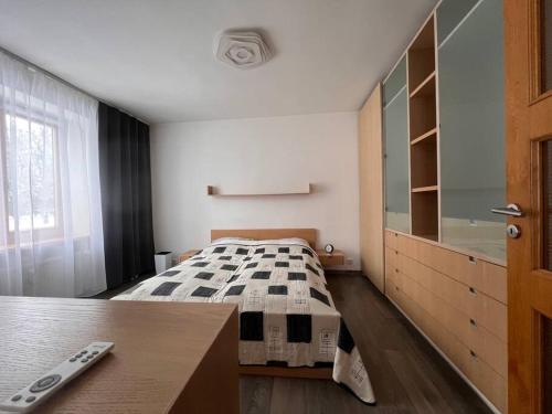 a bedroom with a bed and a dresser and a window at Krásny apartmám CENTRUM in Martin
