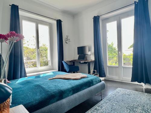 - une chambre avec des rideaux bleus, un lit et un bureau dans l'établissement Fiorella's Cannes Oasis, à Cannes