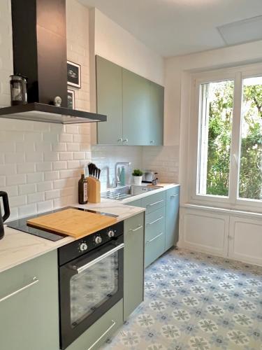 La cuisine est équipée de placards bleus et d'un four avec plaques de cuisson. dans l'établissement Fiorella's Cannes Oasis, à Cannes