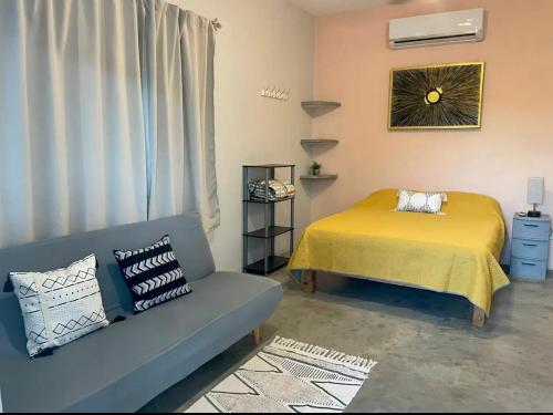 a bedroom with a bed and a couch and a window at La Ventana Apartments Cactus 1 in La Ventana