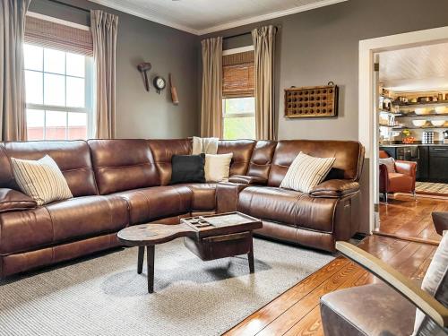 a living room with a brown leather couch at Higgins Downtown Depot in New Bern