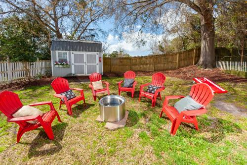 a group of red chairs and a fire pit in a yard at Higgins Downtown Depot in New Bern