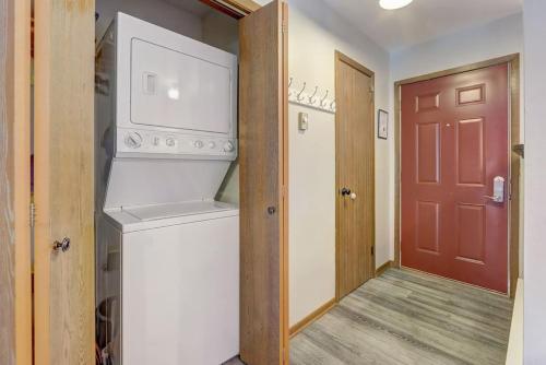 a laundry room with a washer and dryer next to a door at Sloane Condo for Families Golfers and Girls Trips in Wisconsin Dells