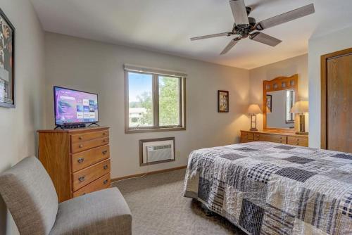 a bedroom with a bed and a tv and a window at Sloane Condo for Families Golfers and Girls Trips in Wisconsin Dells