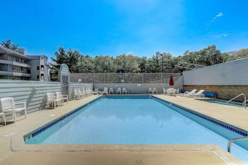 a large swimming pool with chairs and a building at Brown Family Condo for Families Golf Trips and Girls Getaways in Wisconsin Dells