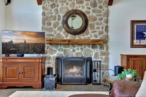 a fireplace in a living room with a stone wall at Lakeshore Haven in Spicewood
