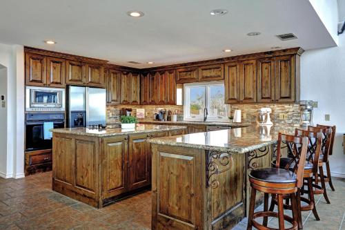 a kitchen with wooden cabinets and a island with bar stools at Lakeshore Haven in Spicewood